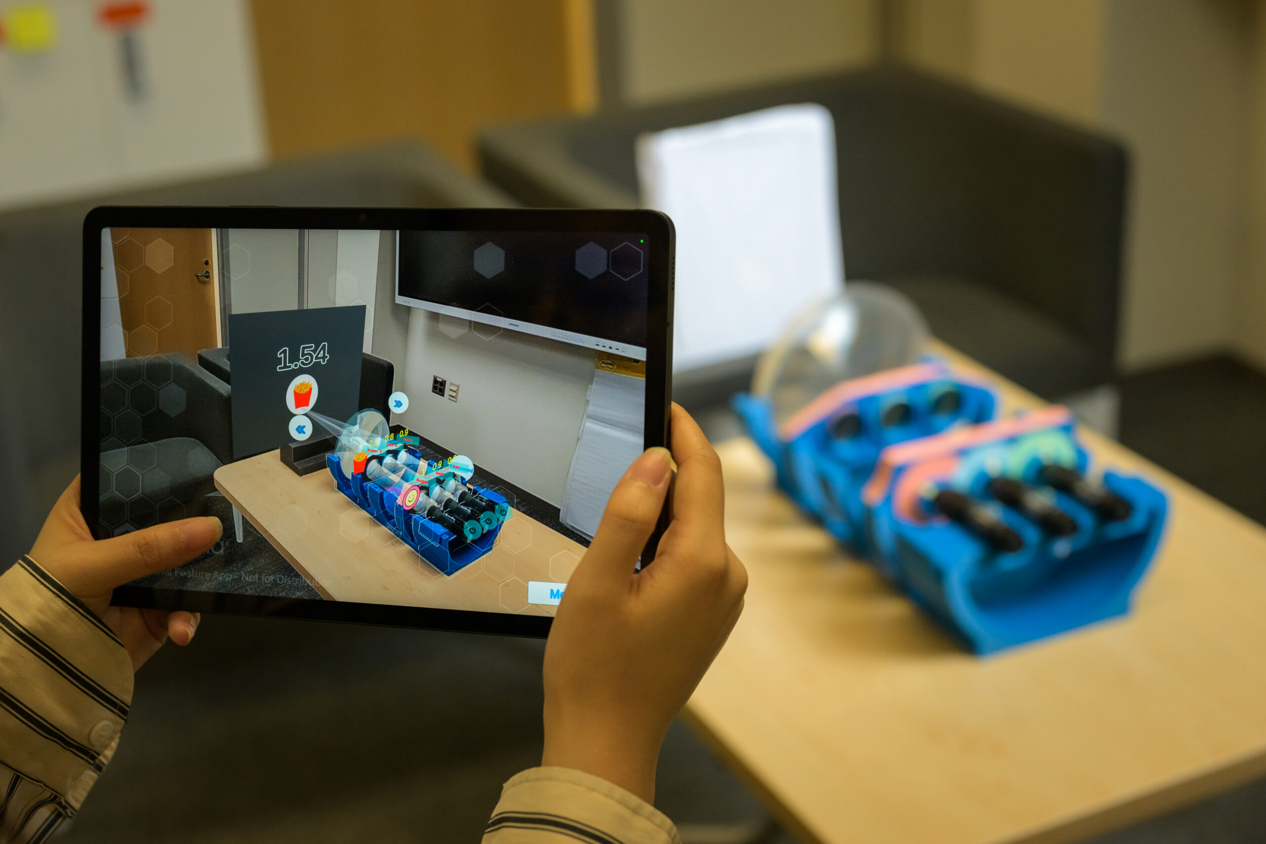 Research Assistant Yi Zhang adjusts a 3D-printed optical device that, when paired with augmented reality, is designed to help children understand how artificial intelligence is used in preference selection, in the lab of Assistant Professor of Computer Science Zhen Bai in Wegmans Hall October 11, 2024. // photo by J. Adam Fenster / University of Rochester